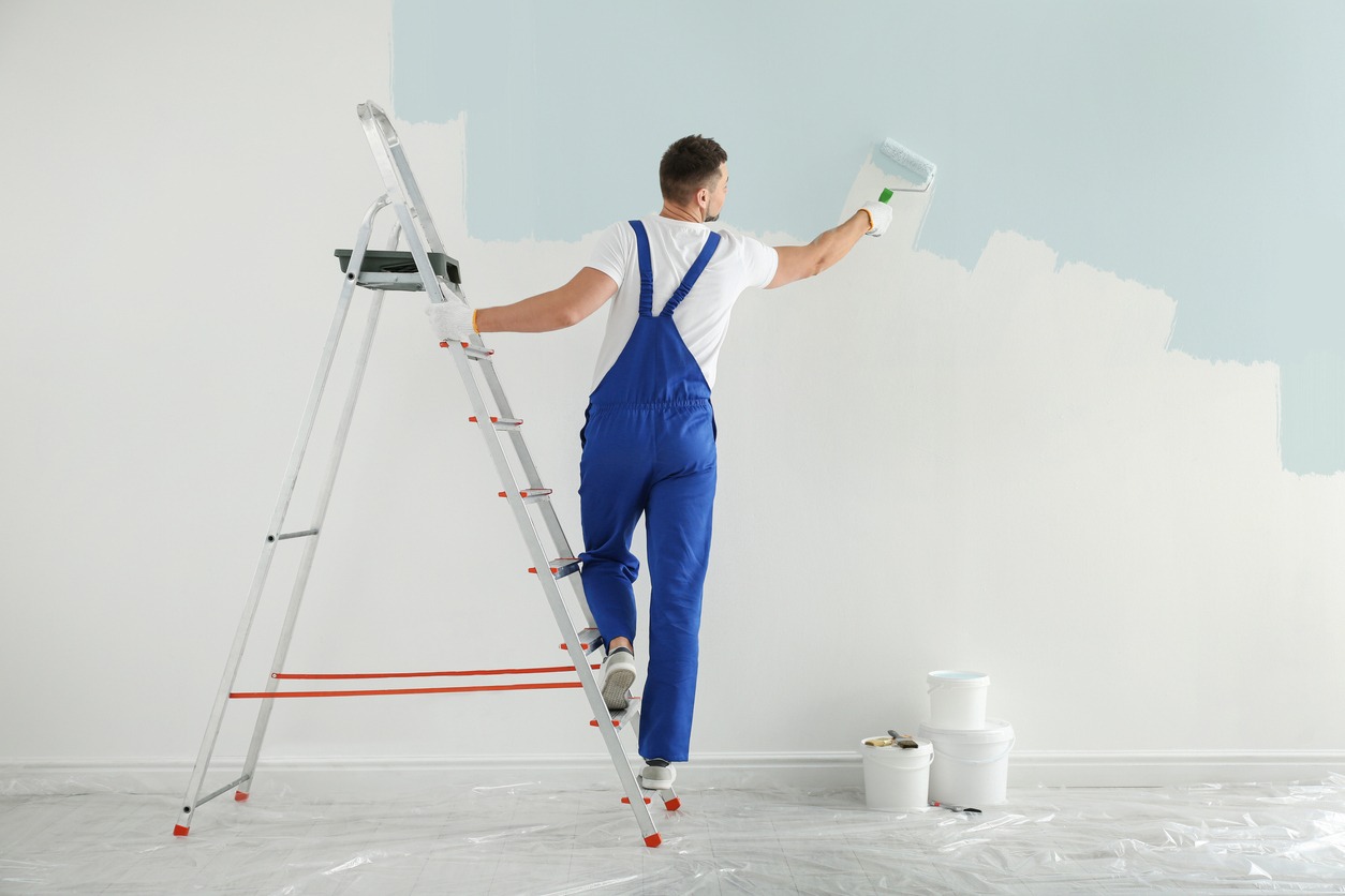Man painting wall with light blue