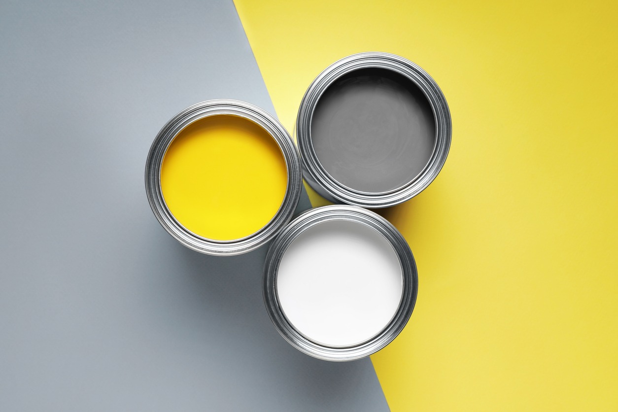 Cans with different paints on color background, flat lay