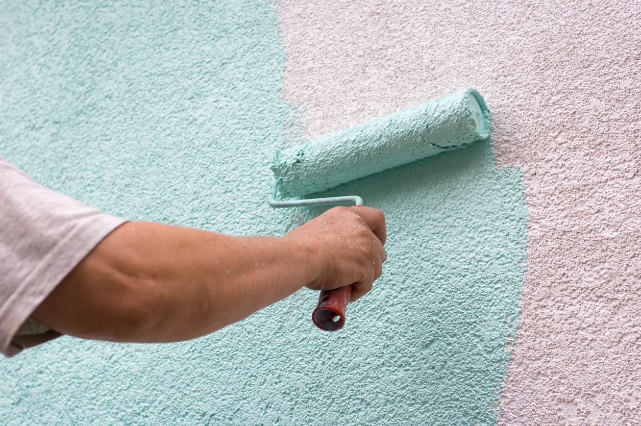 Male worker painting a white wall
