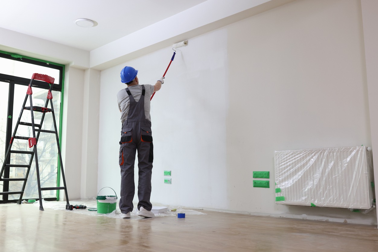 Professional painter paints office wall