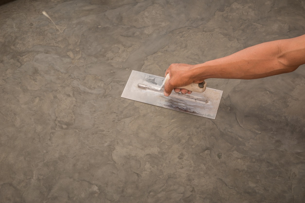 hand using steel trowel to finish Polished wet concrete surface