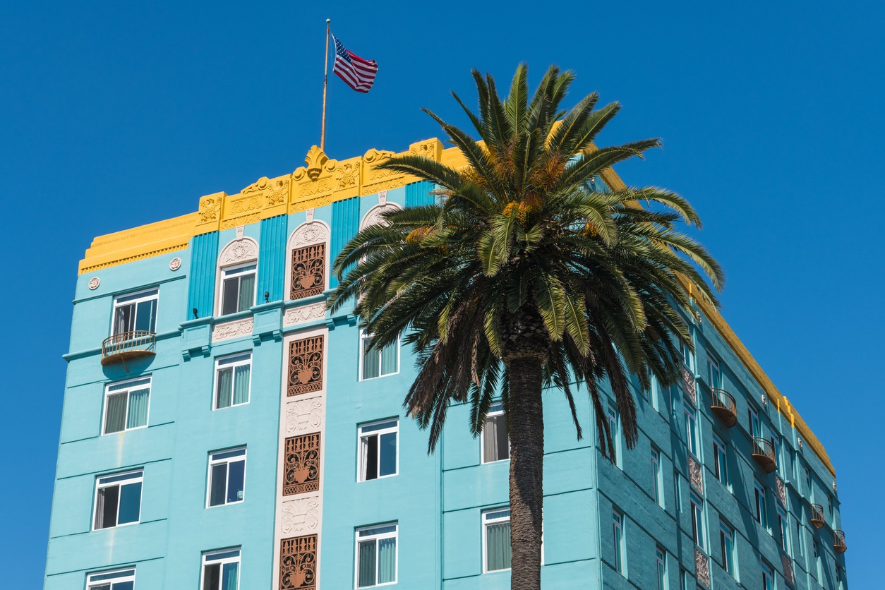 Angled front and side view of a blue art deco style building