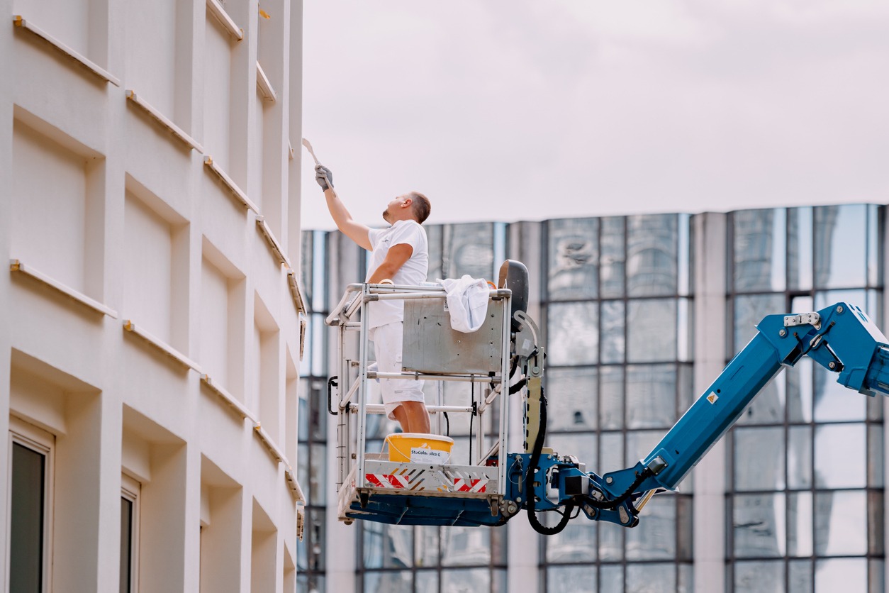 A male worker paints a historic building in the old city center. Restoration and repair