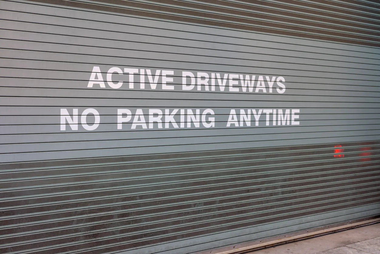 Gate with a message of active driveways and no parking anytime